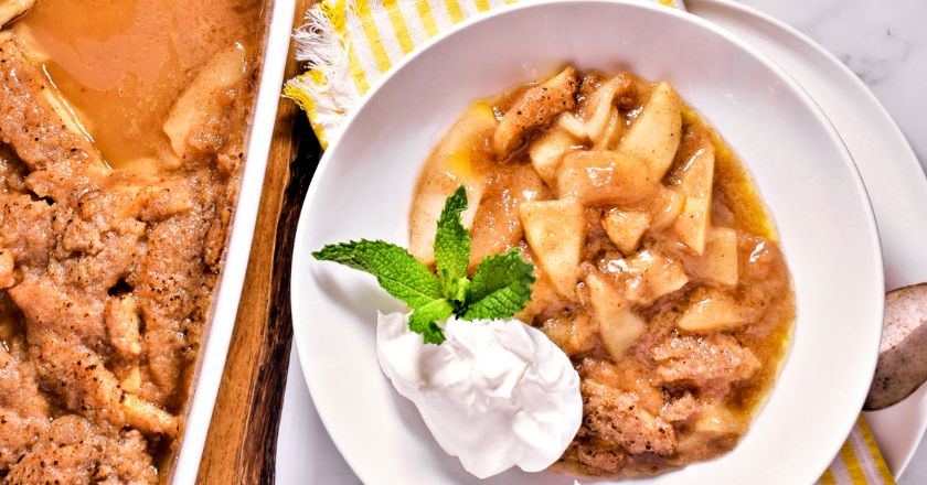 apple pie on a white plate next to a larger serving dish of apple pie