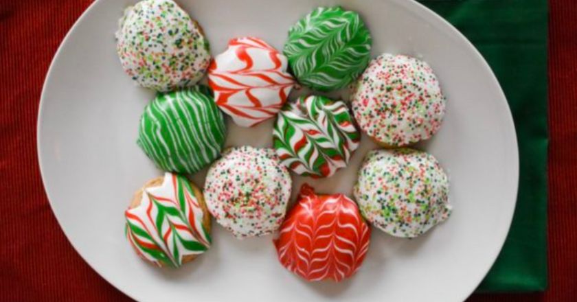 Multi colored Christmas cookies on a white plate