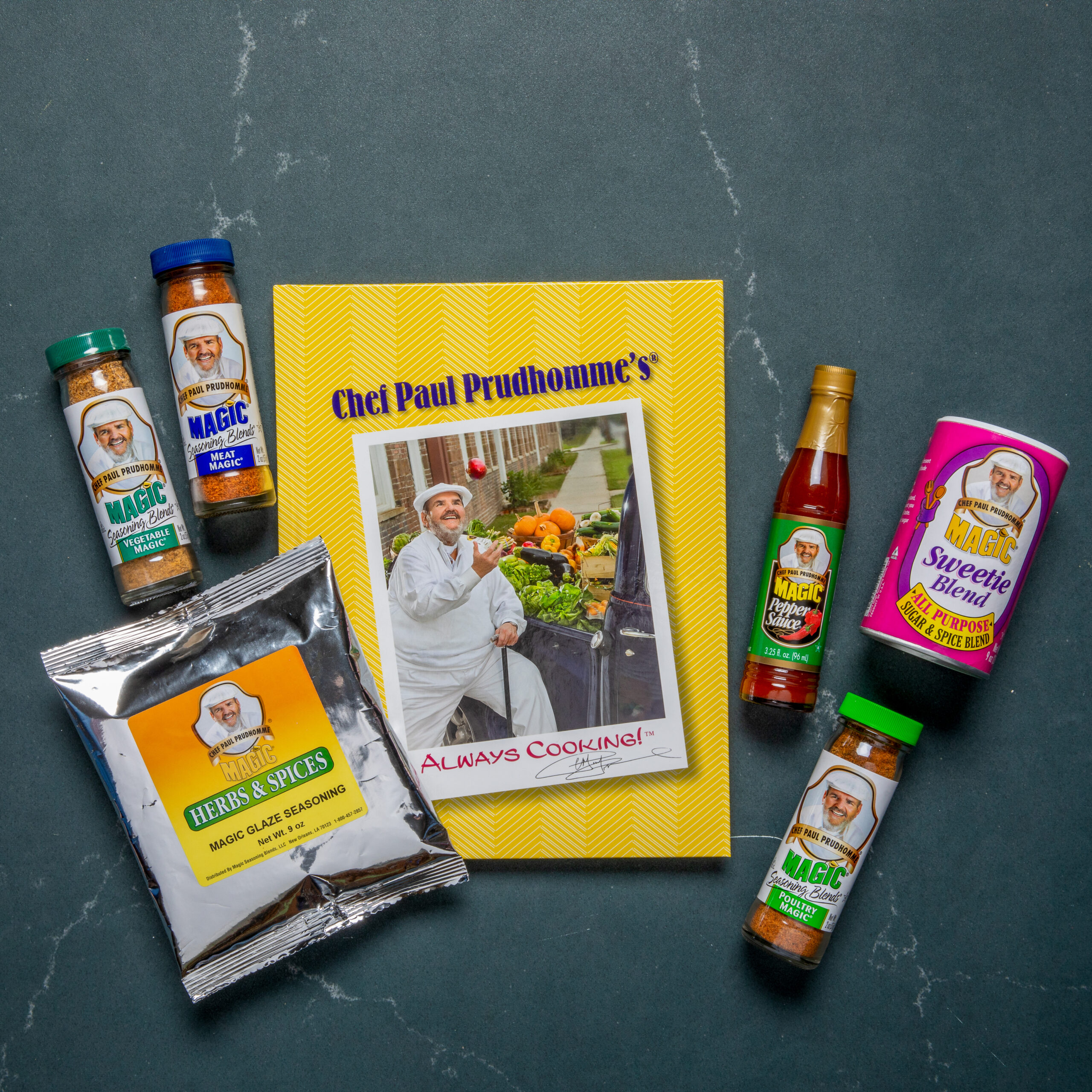 the feast and flavor holiday bundle featuring Chef Paul's Always Cooking cookbook, a bottle of his magic pepper sauce, a bottle of poultry magic, a bottle of vegetable magic, a bottle of meat magic, a canister of his sweetie magic and a silver pouch of magic glaze