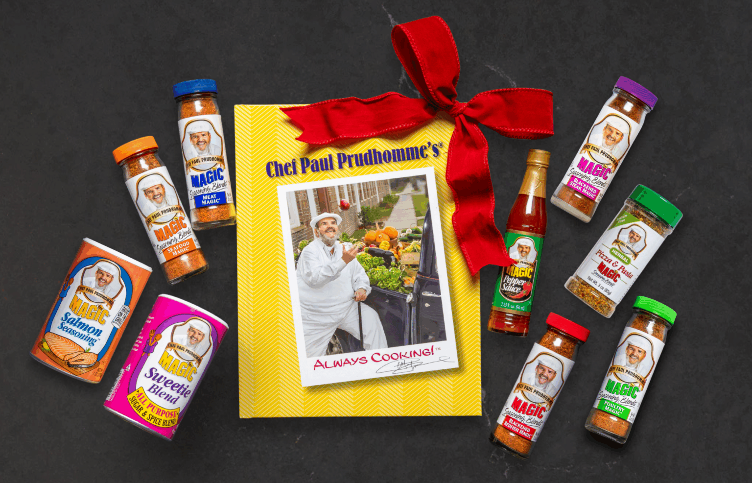 bundle of magic seasoning blend products on a dark surface including book, seasonings and a holiday bow
