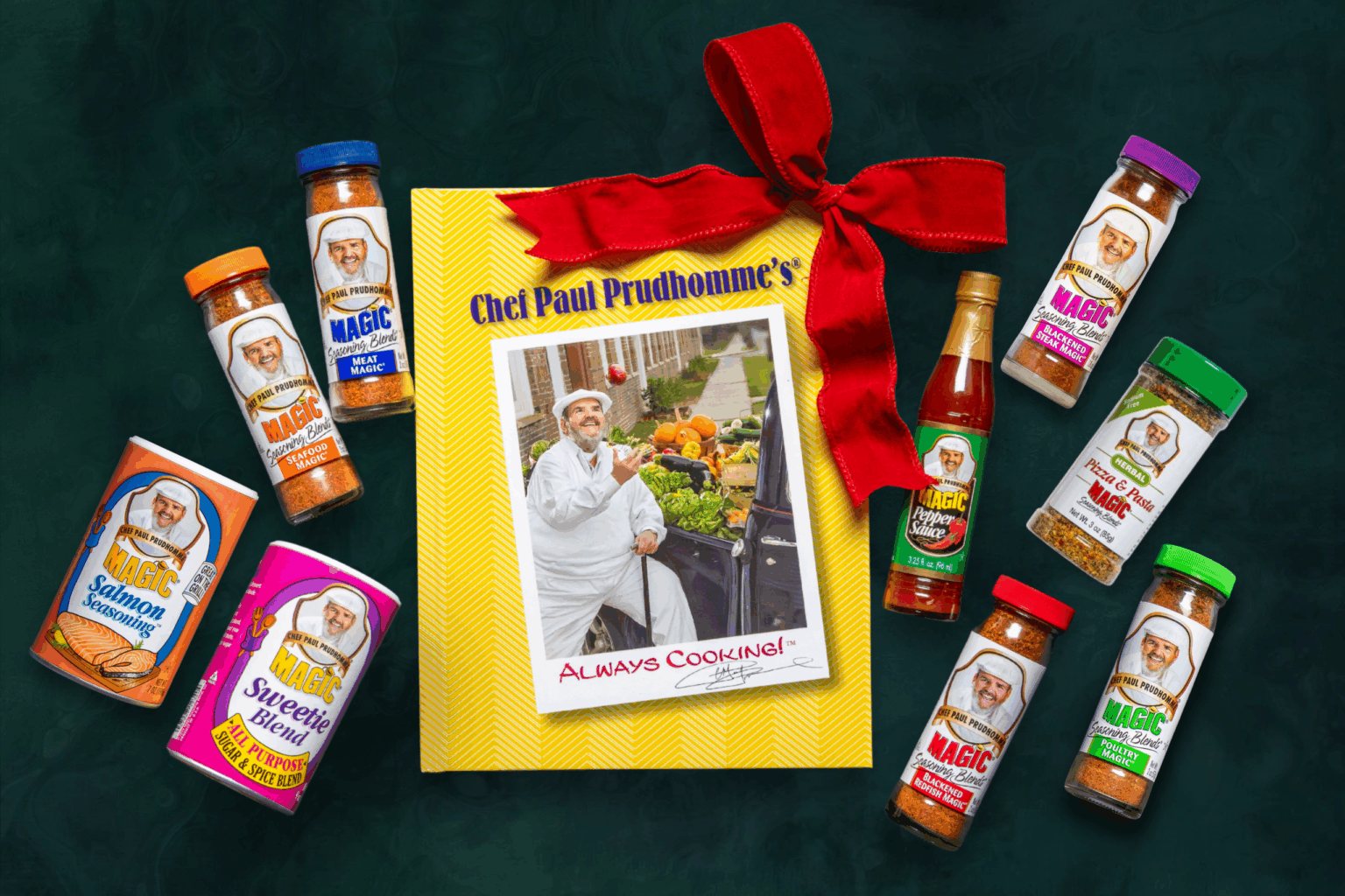 bundle of magic seasoning blend products on a dark surface including book, seasonings and a holiday bow