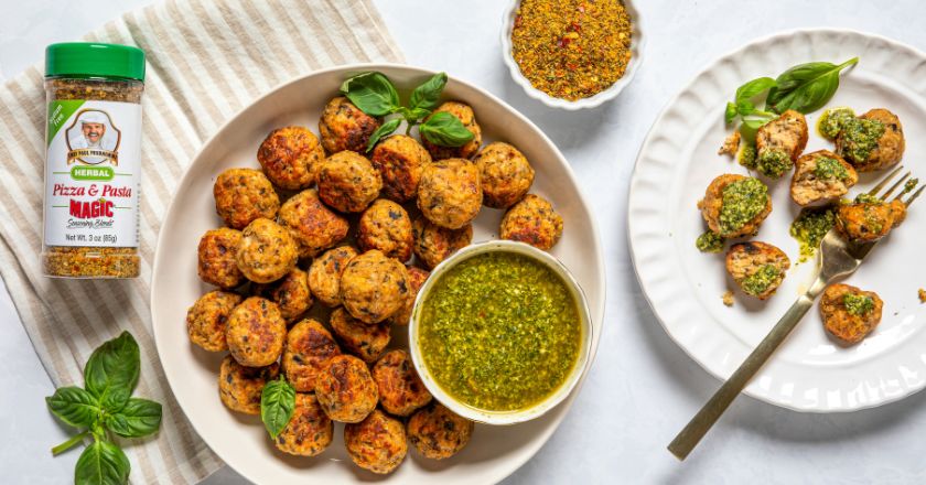 chicken meatballs on a white plate next to another white plate and a small bowl of seasoning