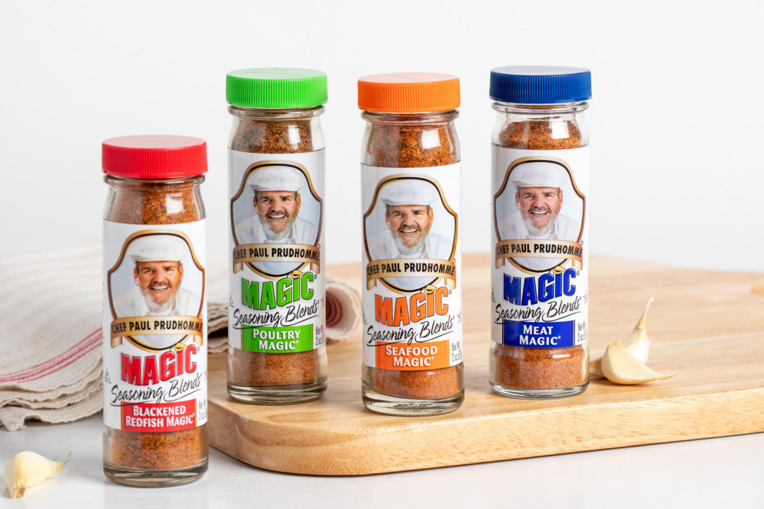 Chef Paul Variety of Magic Seasoning bottles on white countertop and wooden cutting board