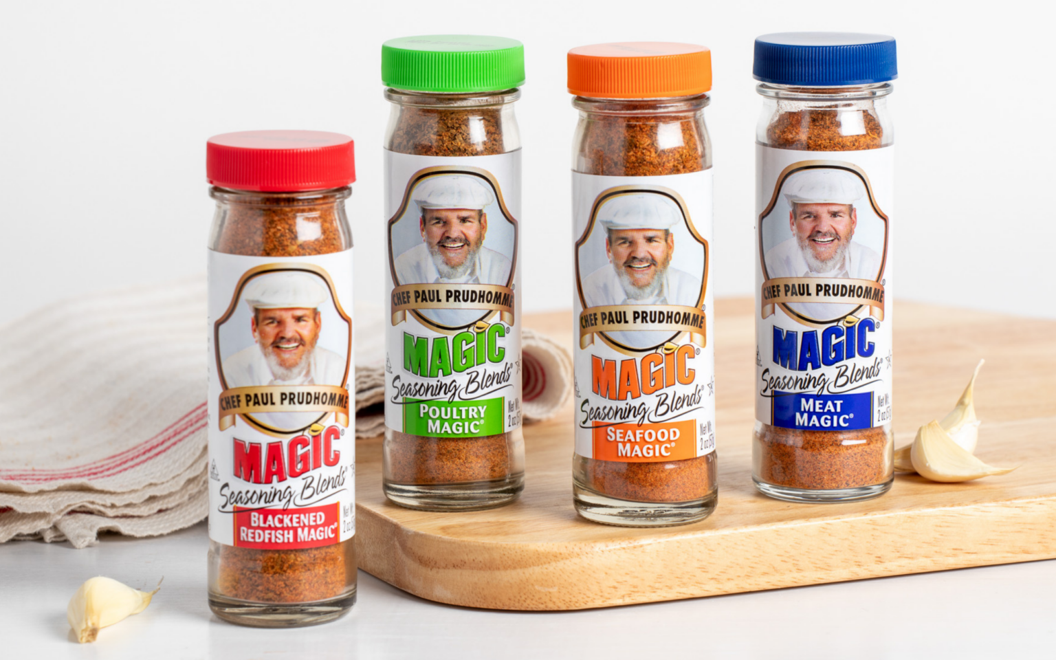 Chef Paul Variety of Magic Seasoning bottles on white countertop and wooden cutting board