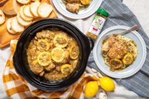Slow Cooker Lemon Garlic Butter Chicken in a crockpot, served over pasta with Pizza & Pasta Magic seasoning.