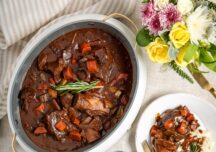 Slow Cooker Beef Short Ribs in a slow cooker, served over mashed potatoes with carrots and gravy.